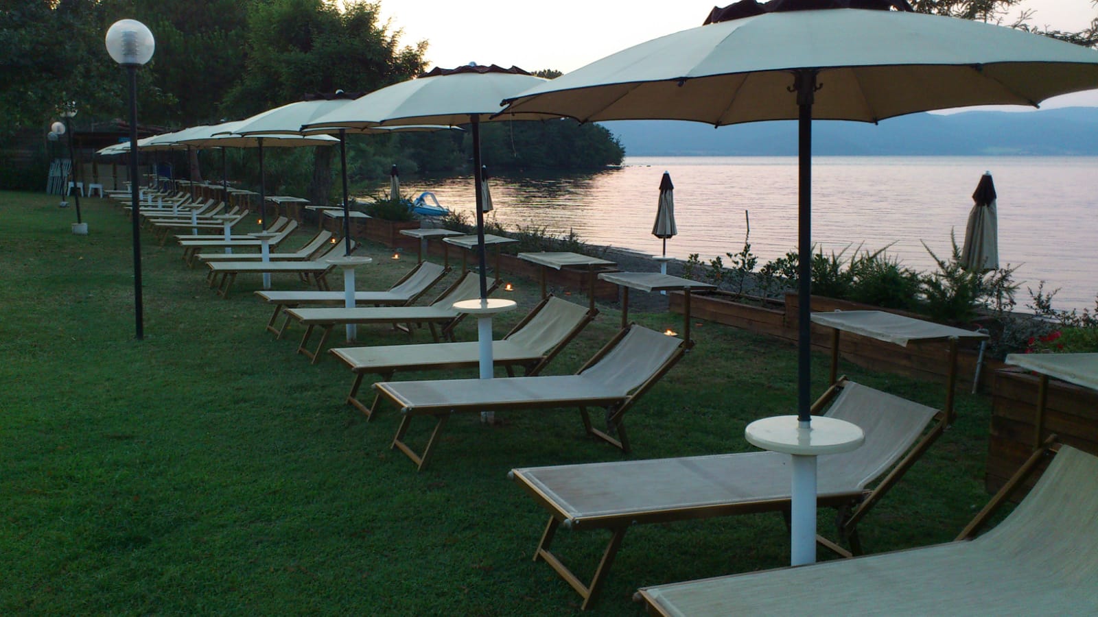 Lettini e ombrelloni in riva al lago